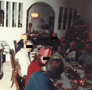 A typical Christmas dinner with Grandma at the far head of the table, sporting her paper crown.
