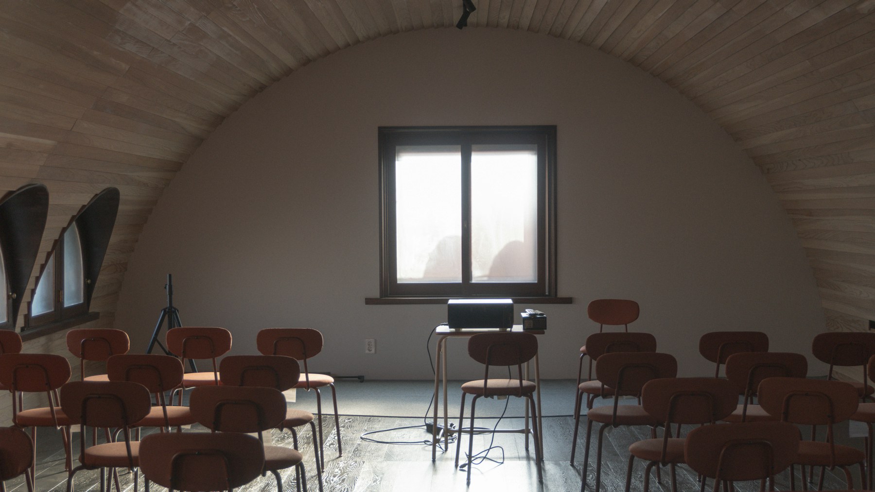 An empty lecture room with chairs and a projector